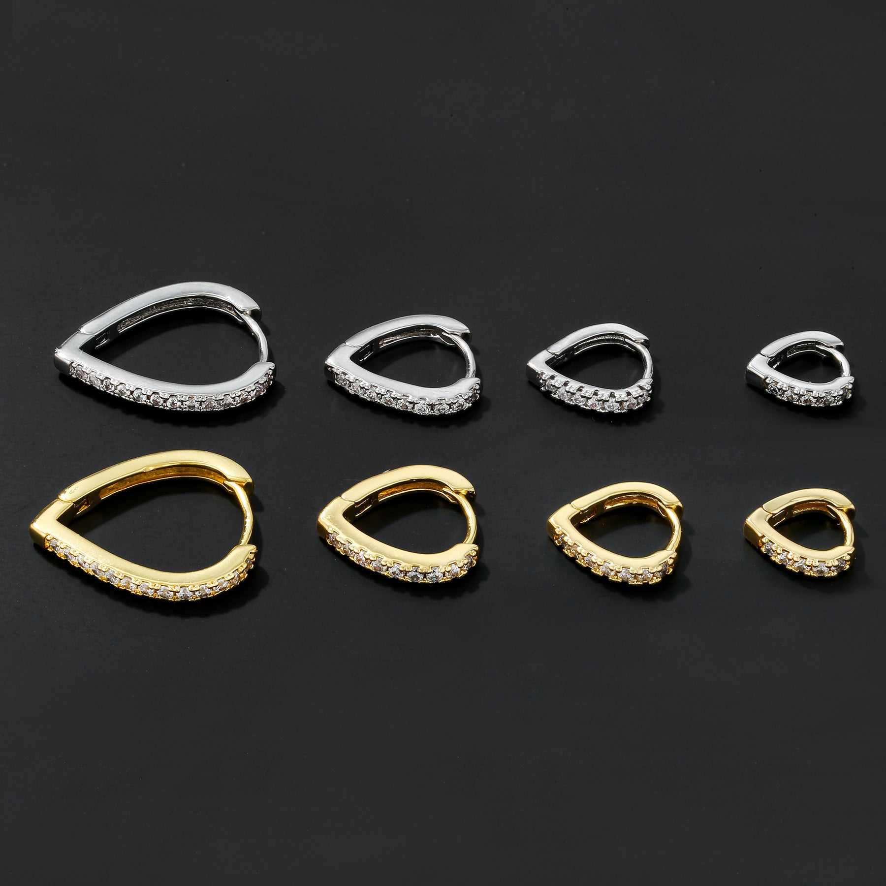 Set of simple temperament summer cool love heart-shaped gold and silver ear clips with rhinestone accents on black background