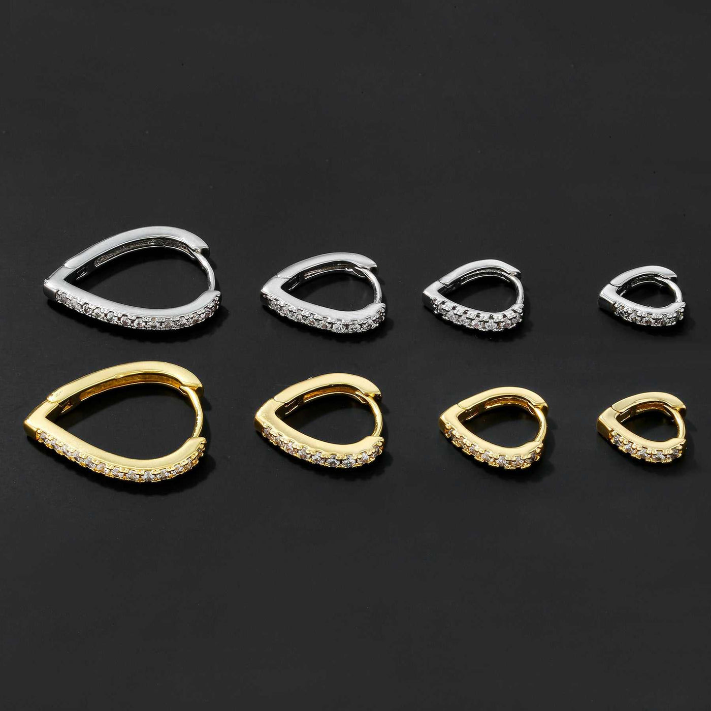 Set of simple temperament summer cool love heart-shaped gold and silver ear clips with rhinestone accents on black background