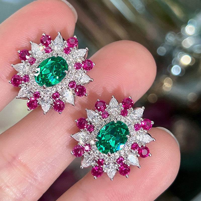 Colorful stud earrings with oval green zircon center, surrounded by white and pink stones in geometric floral design