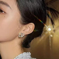 Elegant yellow gold hollowed heart shape ear studs with inlaid zircon worn by woman